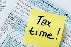 Photo of a sticky note on a tax sheet that says, "tax time"